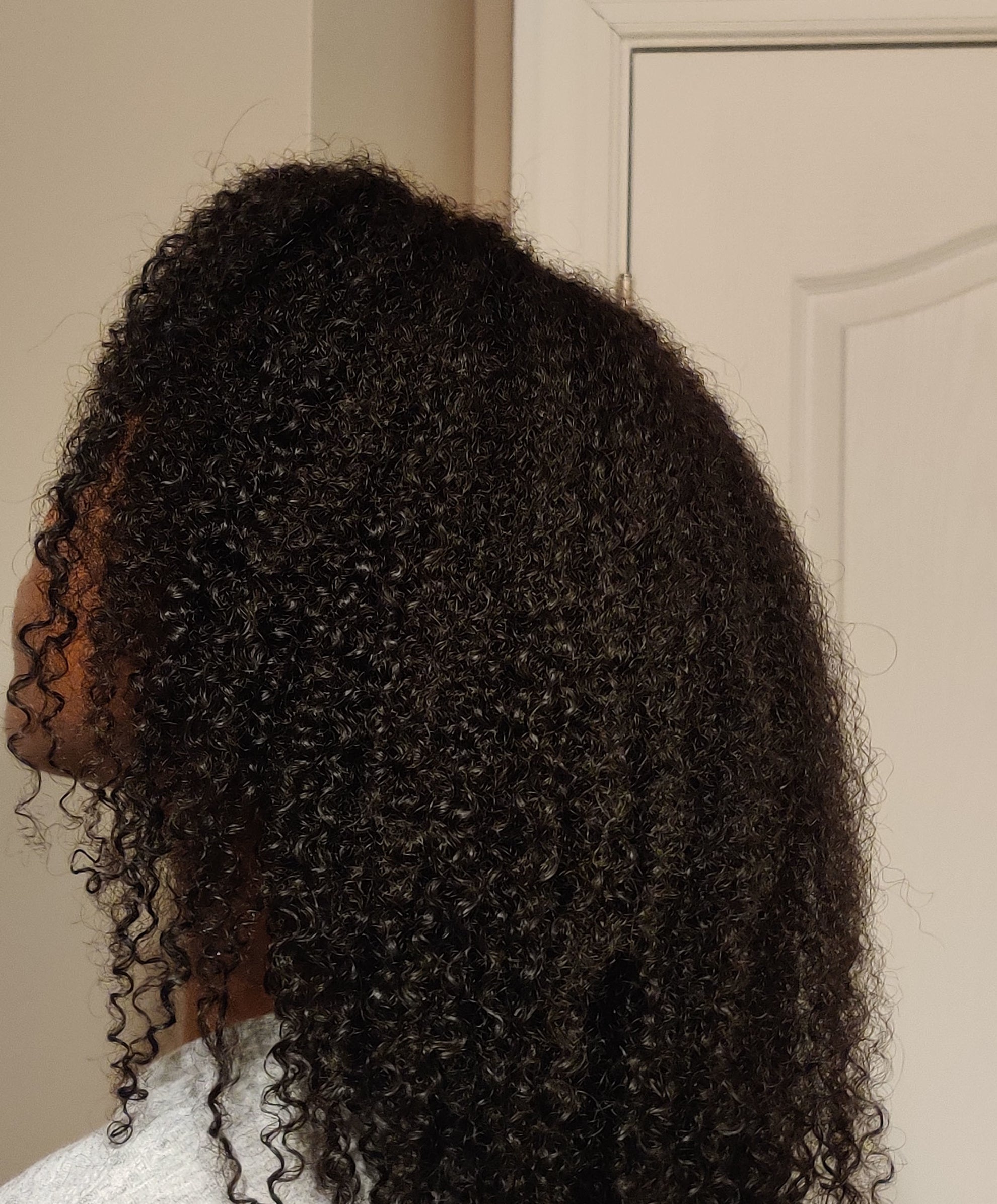 Side profile of a person with shoulder-length curly hair