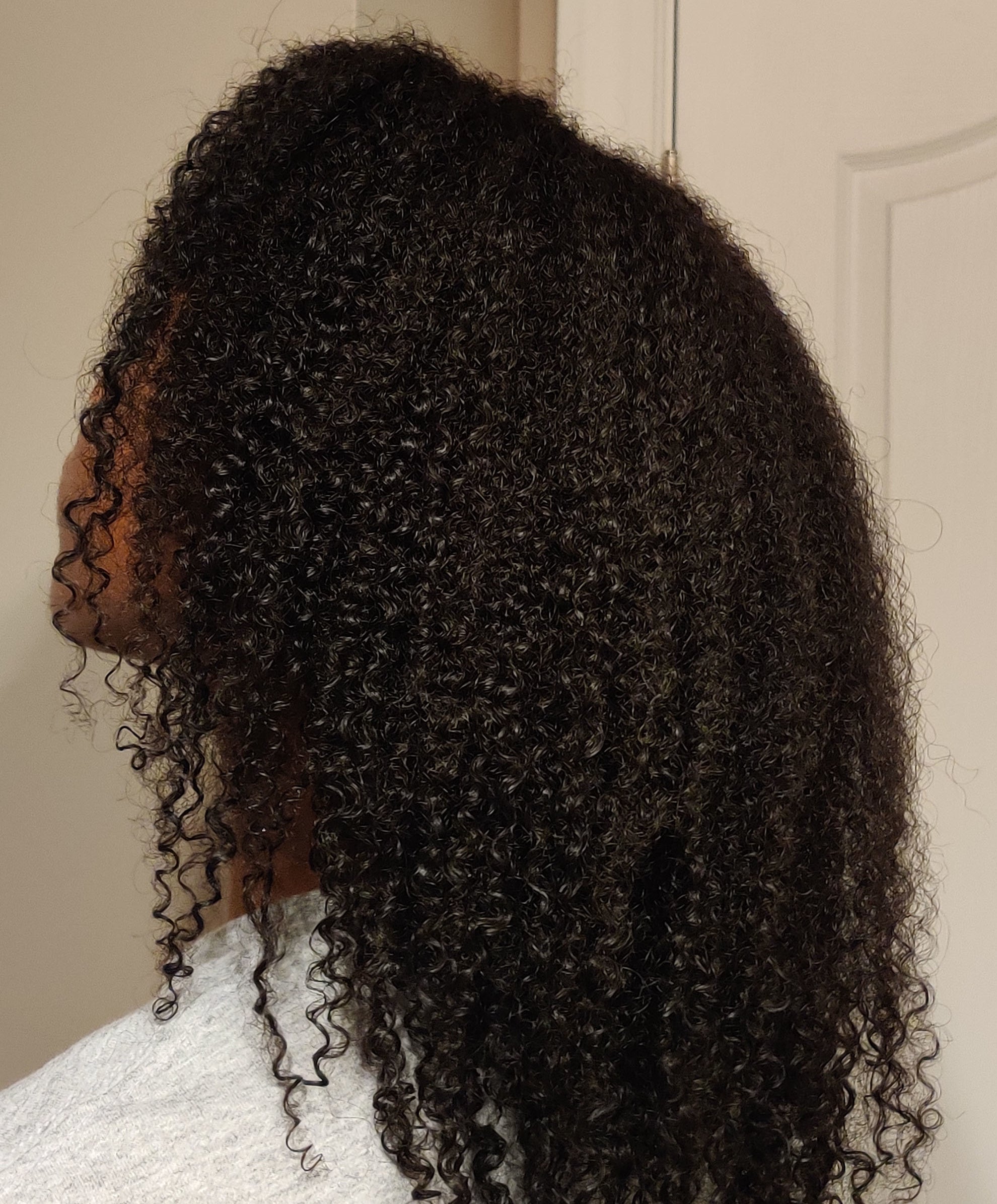 Side profile of a person with shoulder-length curly hair