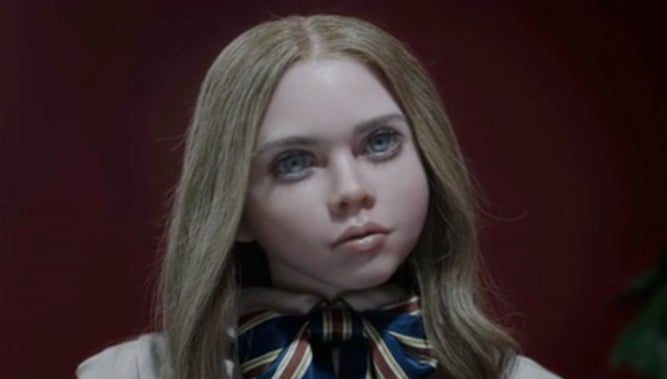 Life-like doll with striking features wearing a scarf, from the movie &#x27;Megan.&#x27;