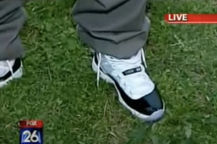 Close-up of a person's feet wearing classic sneakers on grass, focus on shoe design