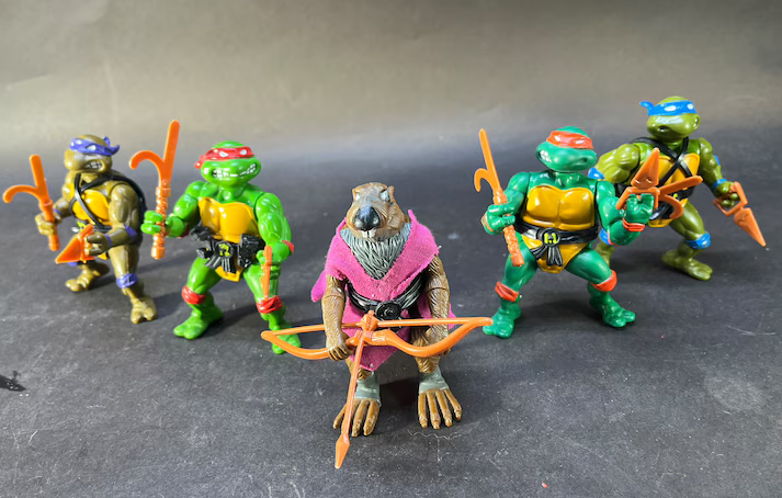 Four Teenage Mutant Ninja Turtle figures with Master Splinter in front, displayed on a surface