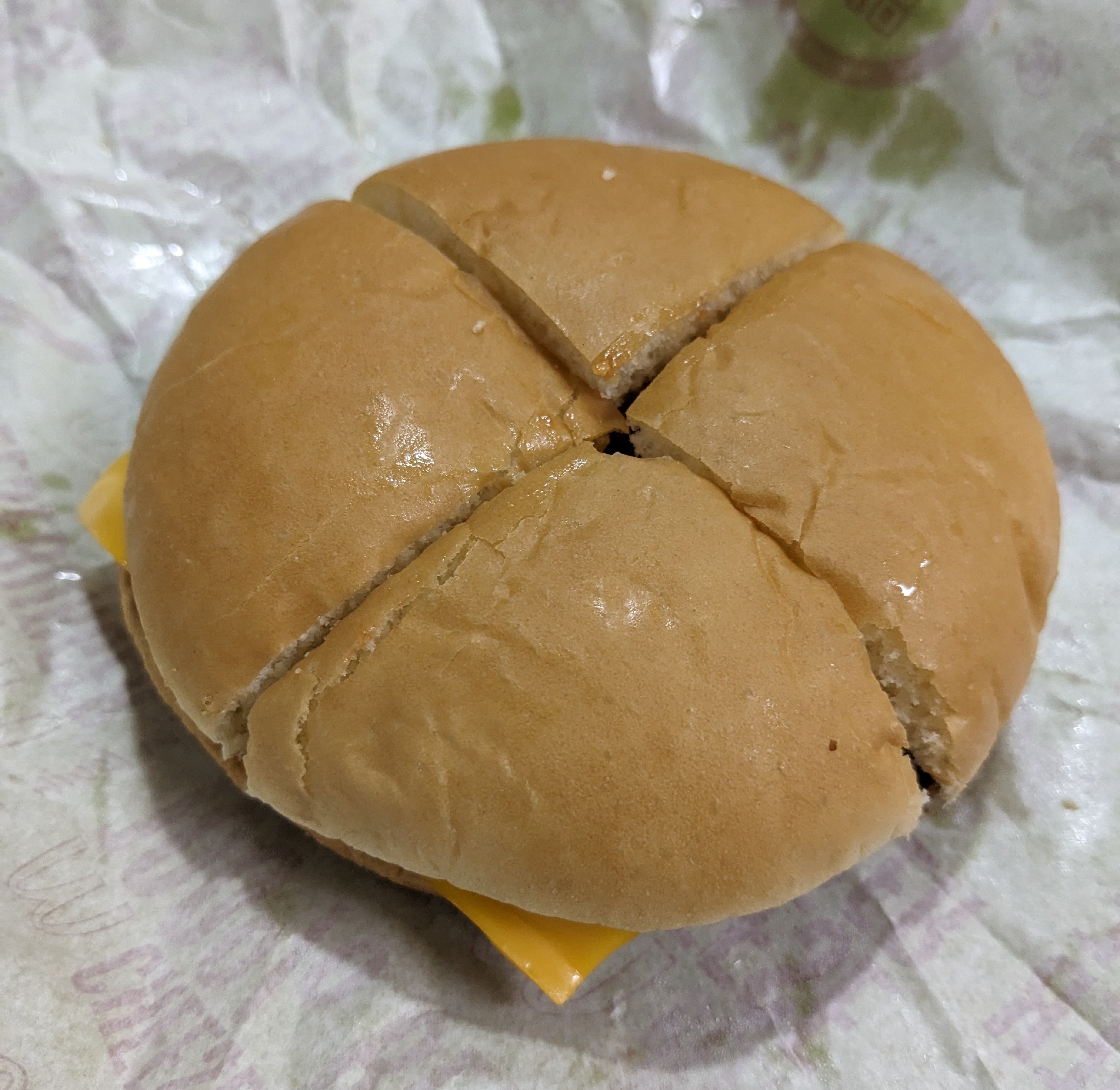 チーズバーガーが紙に包まれています。