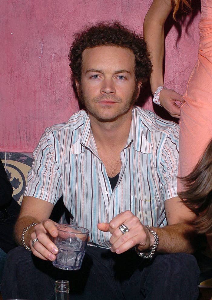 Danny Masterson in striped button-down shirt holding a glass
