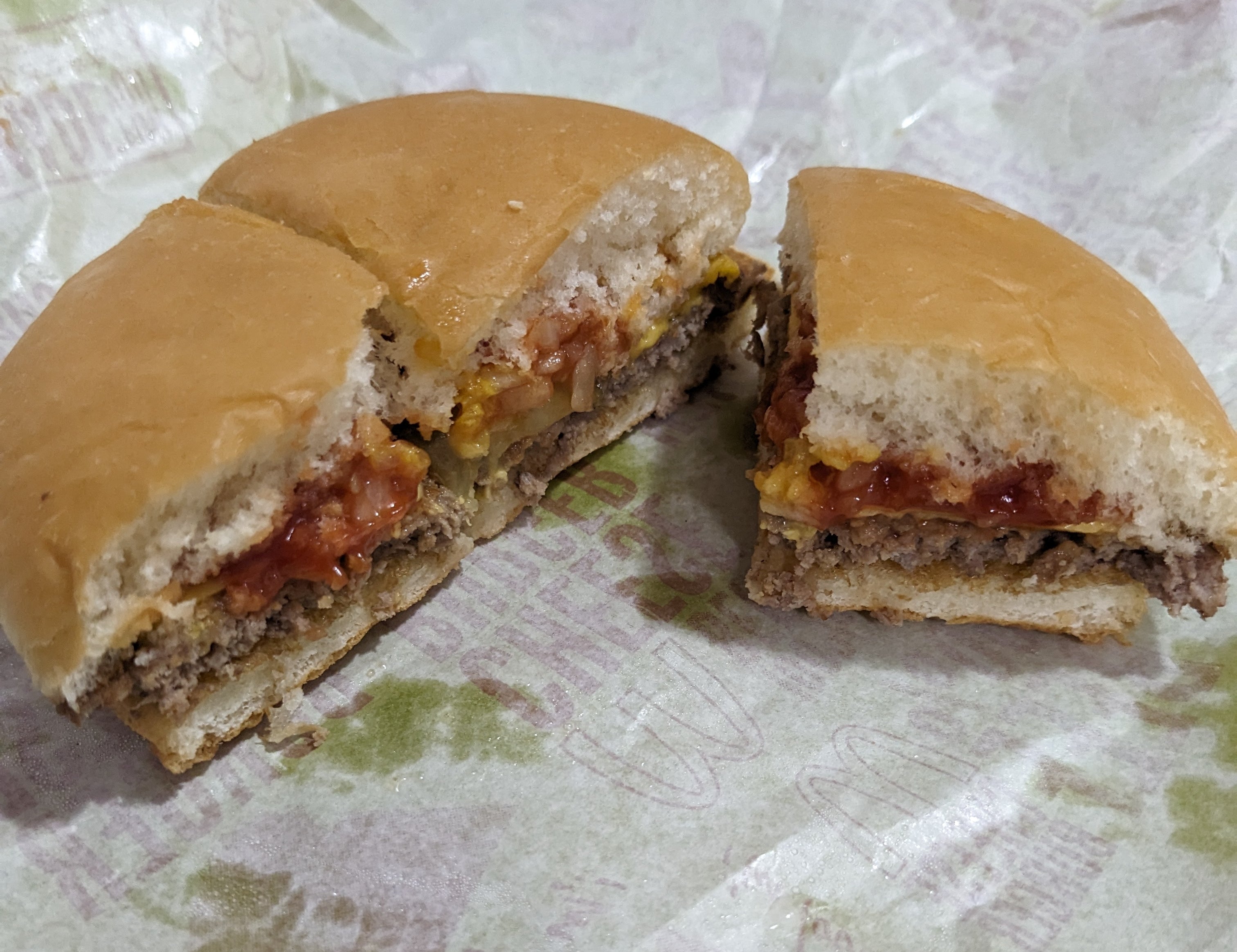 ハンバーガーが紙にのっていて、真ん中で切られている。