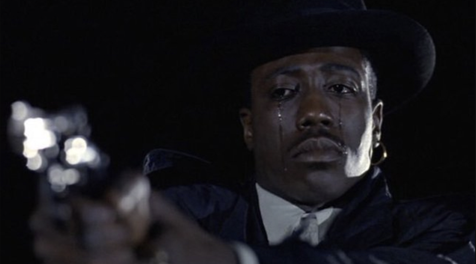 Scene from a &#x27;New Jack City&#x27; showing Wesley Snipes&#x27; character holding a gun, tears rolling down his face.