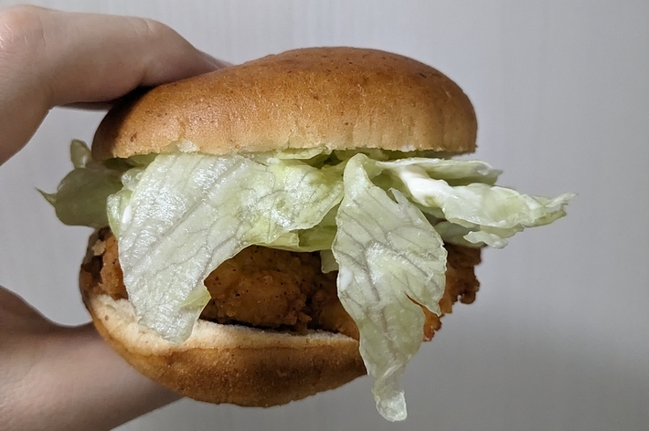手に持たれたチキンバーガー