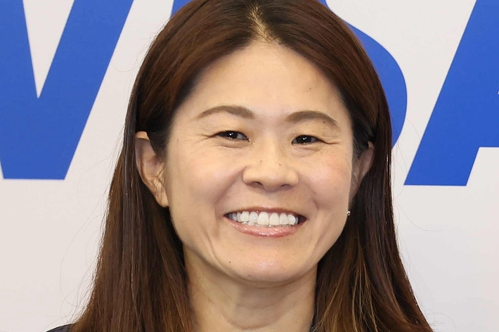 佐々木主浩の前にいる微笑む女性、ジャケットとネックレスを着用。