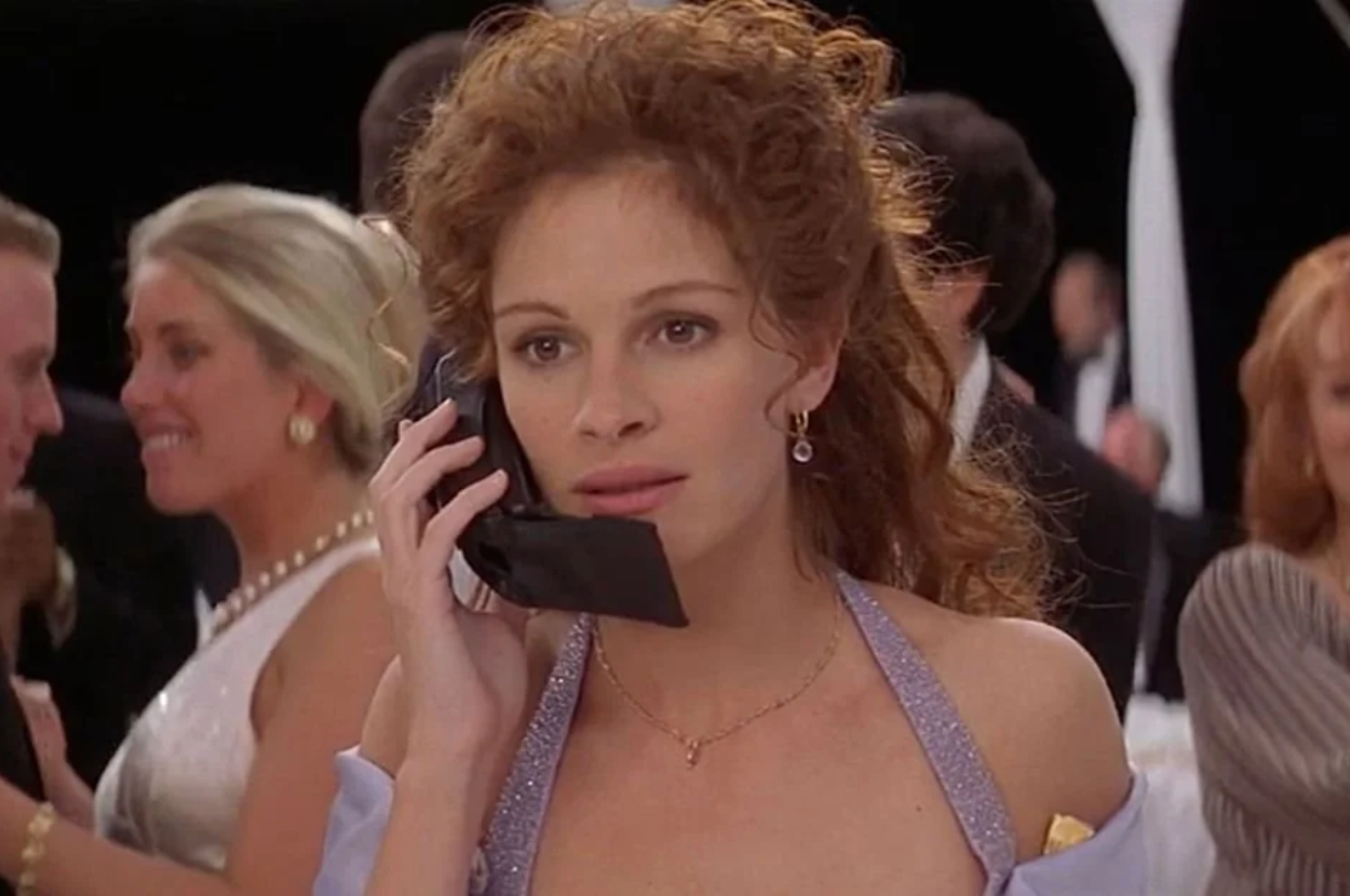Vivian (Julia Roberts) in an elegant evening gown speaking on a cell phone at a social event