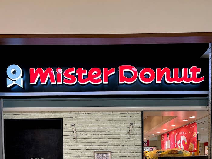 Signage of &#x27;Mister Donut&#x27; shop with donut and coffee cup icon above the text