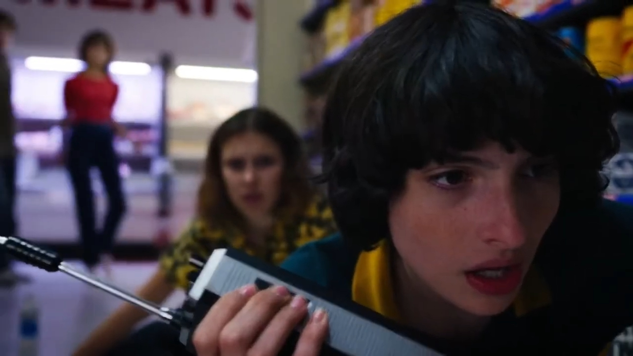 Mike Wheeler from Stranger Things clutches his chest in shock, while Max Mayfield reacts in the background