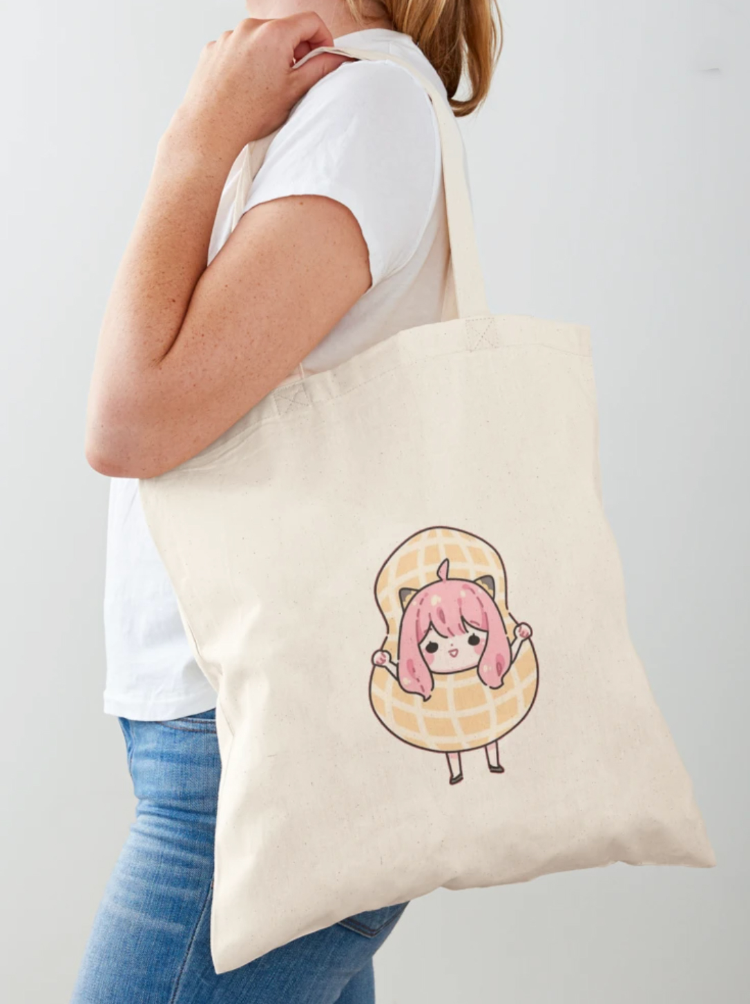 Person holding a tote with a print of Anya in a peanut costume.
