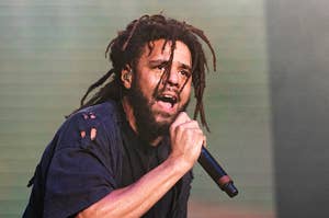 J. Cole performs on stage, holding a microphone, with a passionate expression