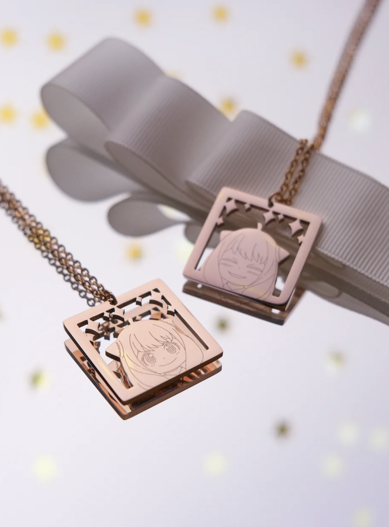 Two layered square necklaces with intricate etching, displayed against a soft backdrop