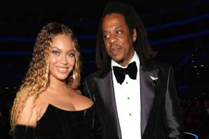 Beyoncé in a black velvet dress and Jay-Z in a black suit with bow tie, posing together at an event