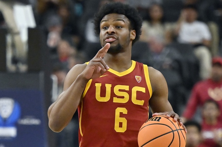 USC basketball player #6 in motion, gesturing while holding a basketball on the court