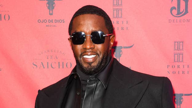 Man in black suit and sunglasses posing on the red carpet