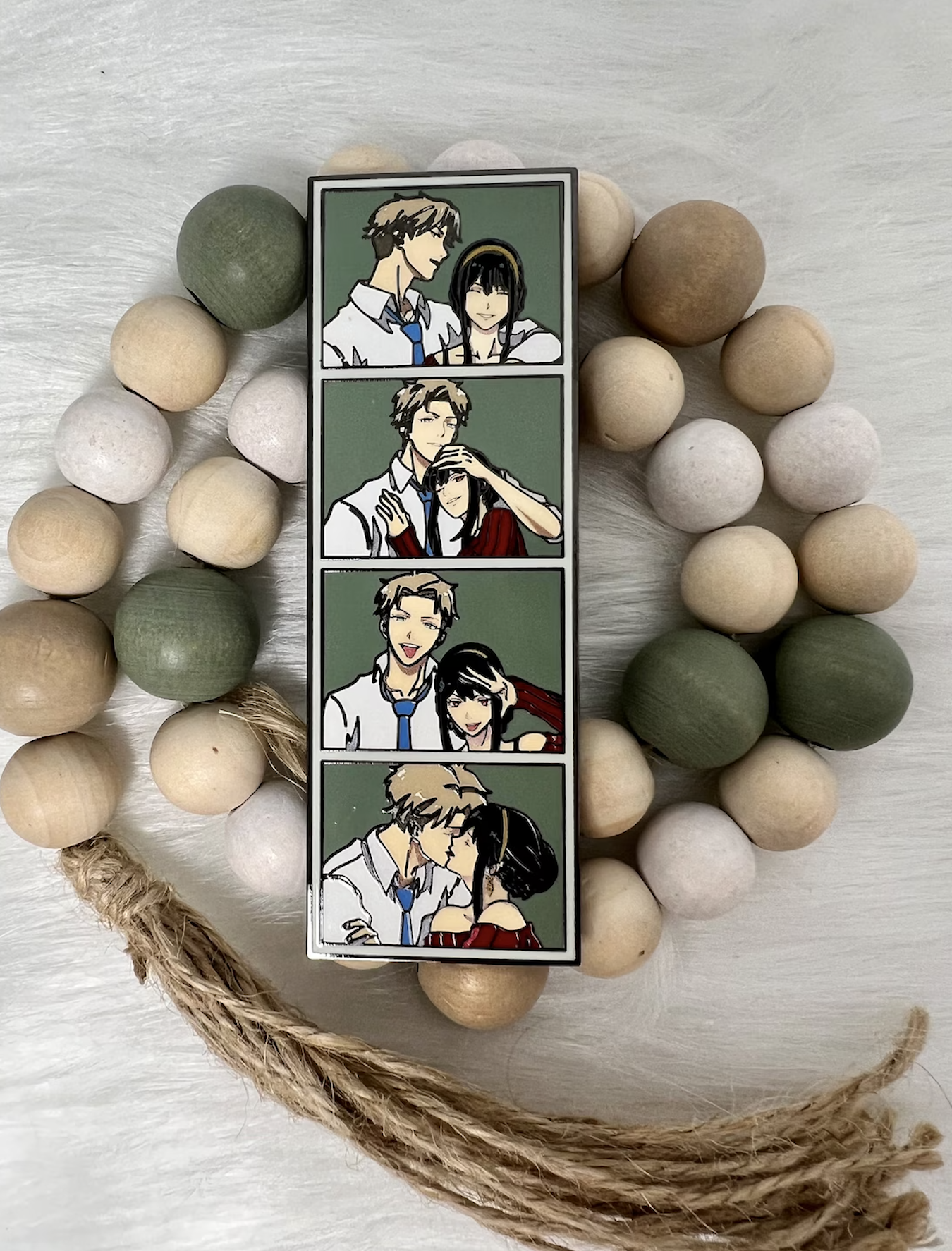 Decorative frame with sequential art of a couple&#x27;s romantic moments, surrounded by wooden beads on a surface