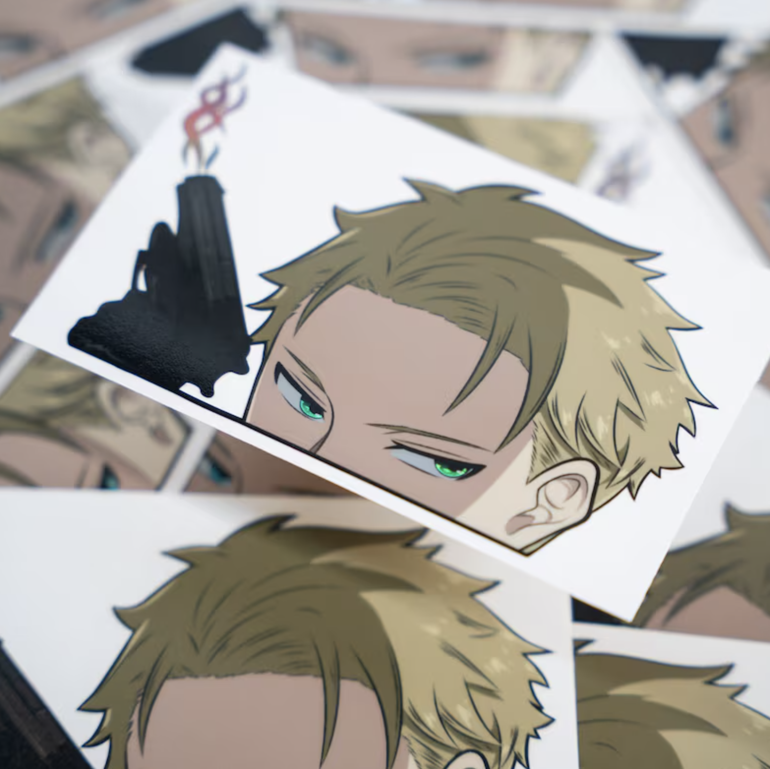 Assorted printed anime character stickers spread out, featuring close-up of a male character&#x27;s face holding a weapon