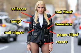 Celebrity in a black outfit embellished with oversized accessories resembling grooming tools