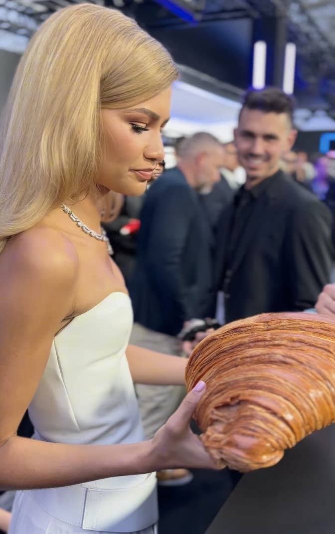 Closeup of Zendaya being given a giant croissant