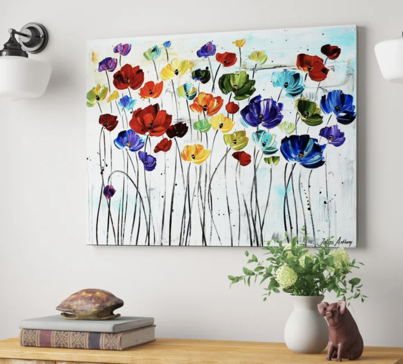 Abstract painting of assorted flowers displayed above a shelf with decorative figures