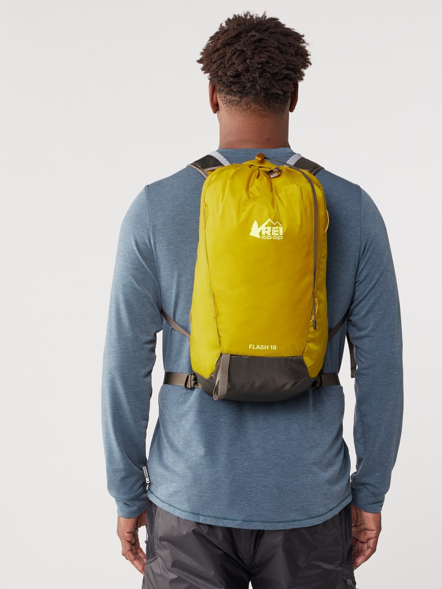 Person with a yellow backpack standing with their back to the camera