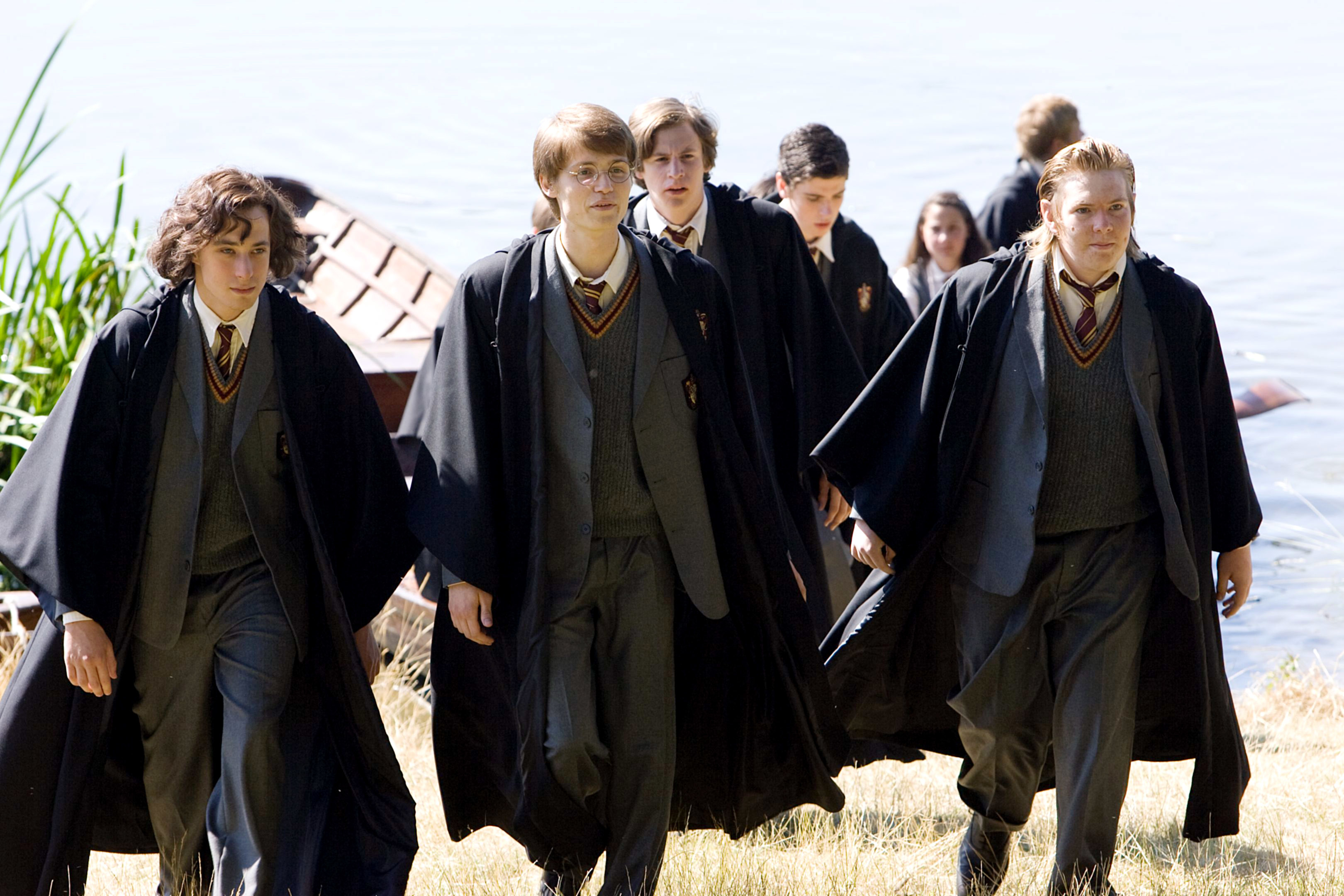 Harry Potter characters walking by a lake in Hogwarts uniform