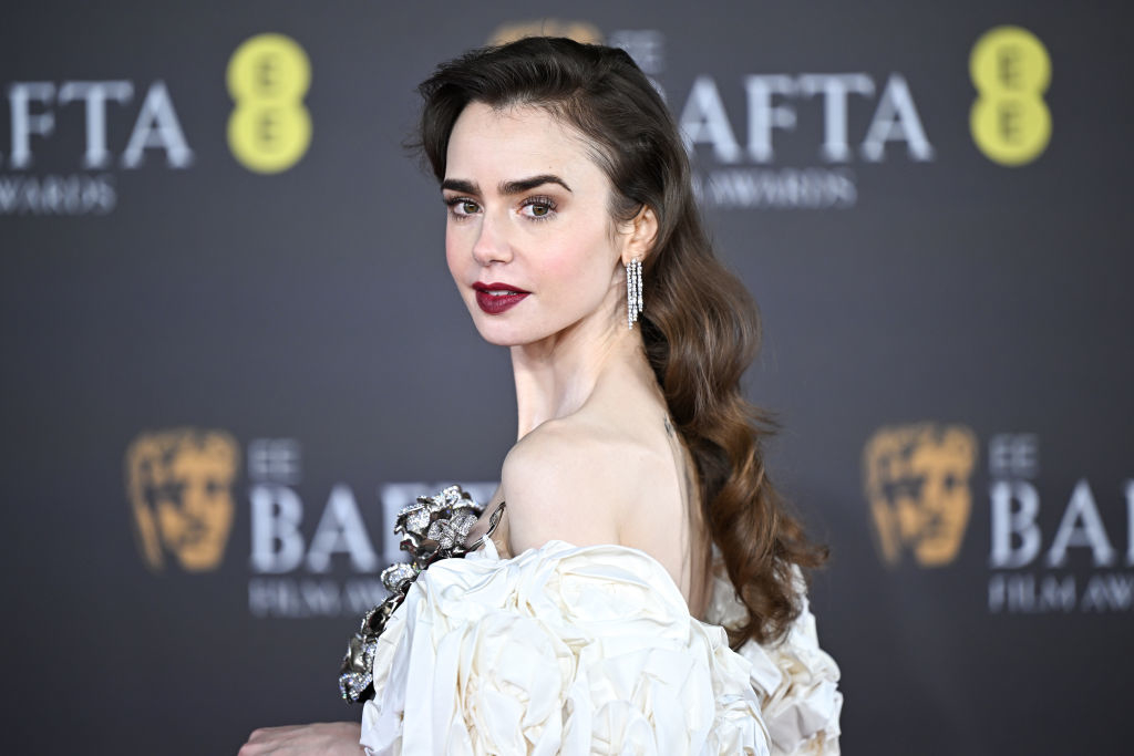 Woman in an elegant dress with ruffled detail posing on the BAFTA red carpet