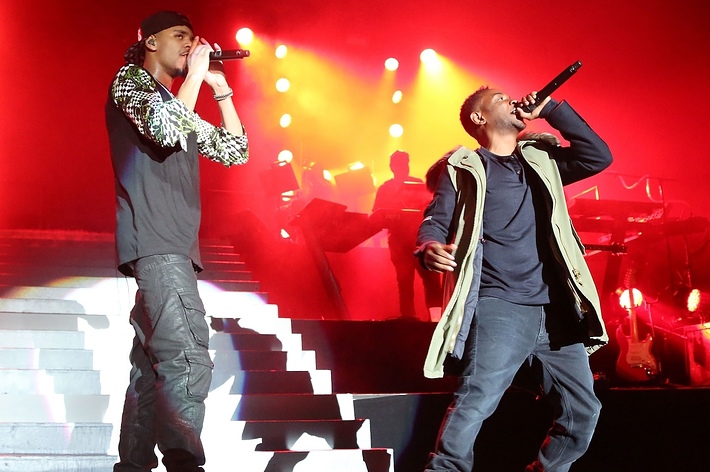 Eminem and Justin Timberlake perform on stage with a band in the background