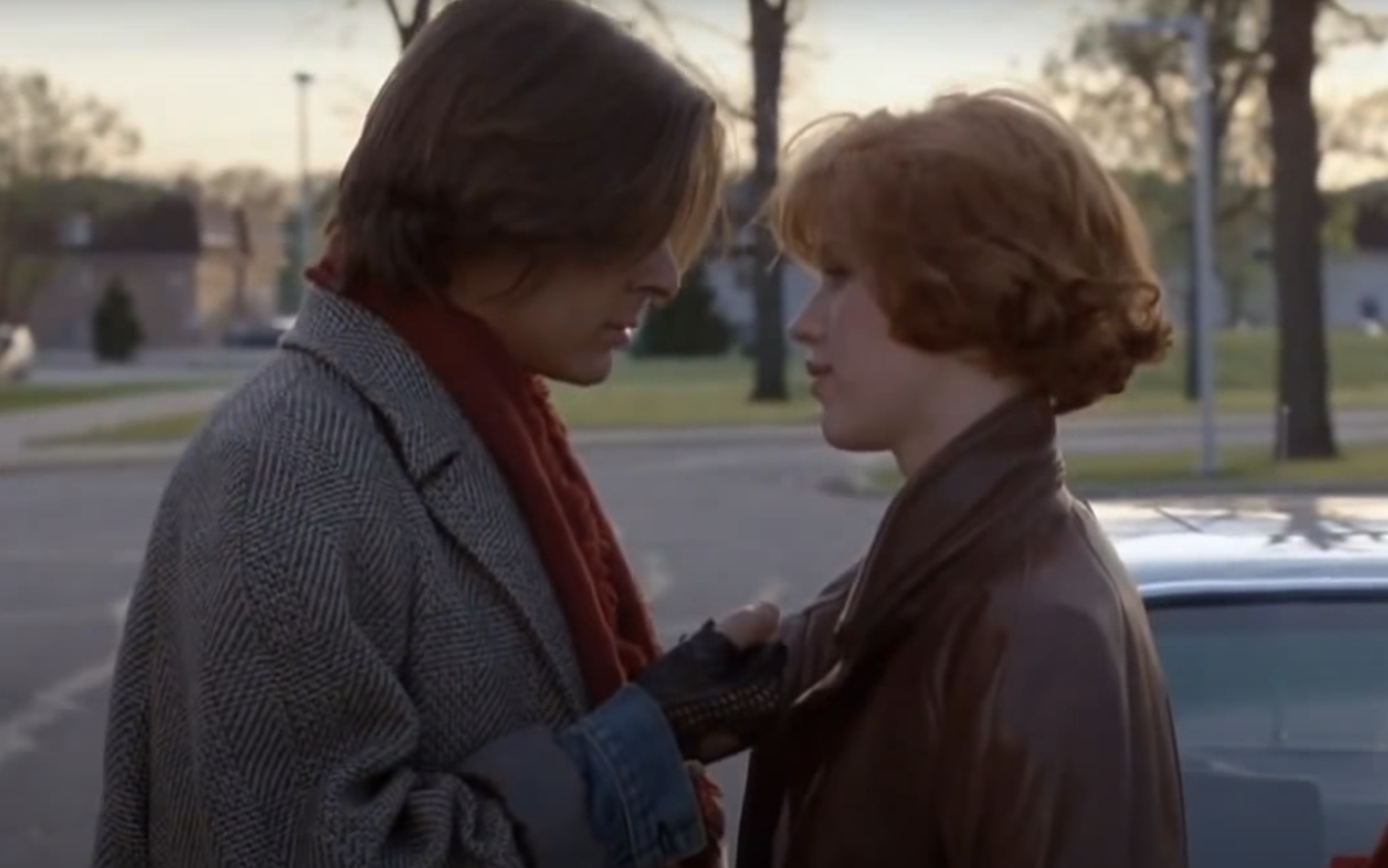 Two characters from the movie Breakfast Club, John Bender and Claire Standish, face each other outdoors