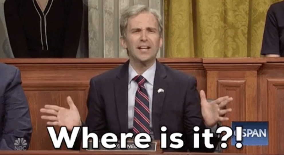 Man in suit gestures with confusion on a TV show set, mimicking a political figure. Text reads, &quot;Where is it?!&quot;