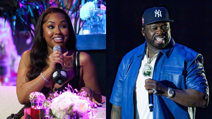 Megan Thee Stallion seated with microphone; 50 Cent standing in blue outfit, both smiling