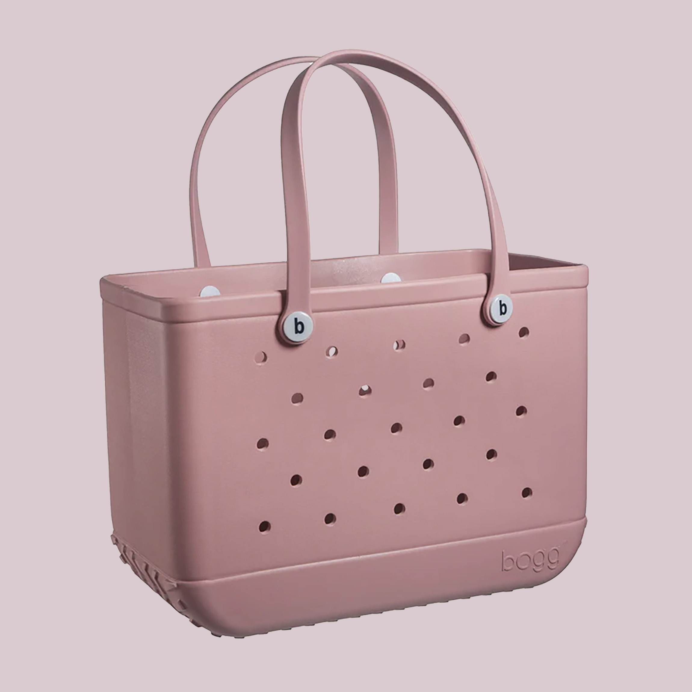 A minimalist pink Bogg Bag with a unique hole pattern, intended for versatile use