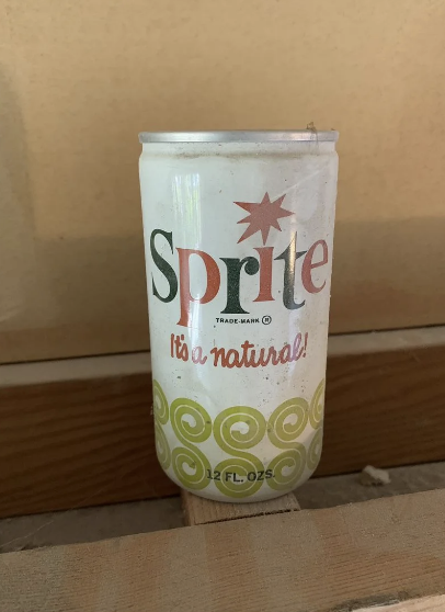 Vintage Sprite can with slogan &quot;It&#x27;s a natural!&quot; on a wooden surface