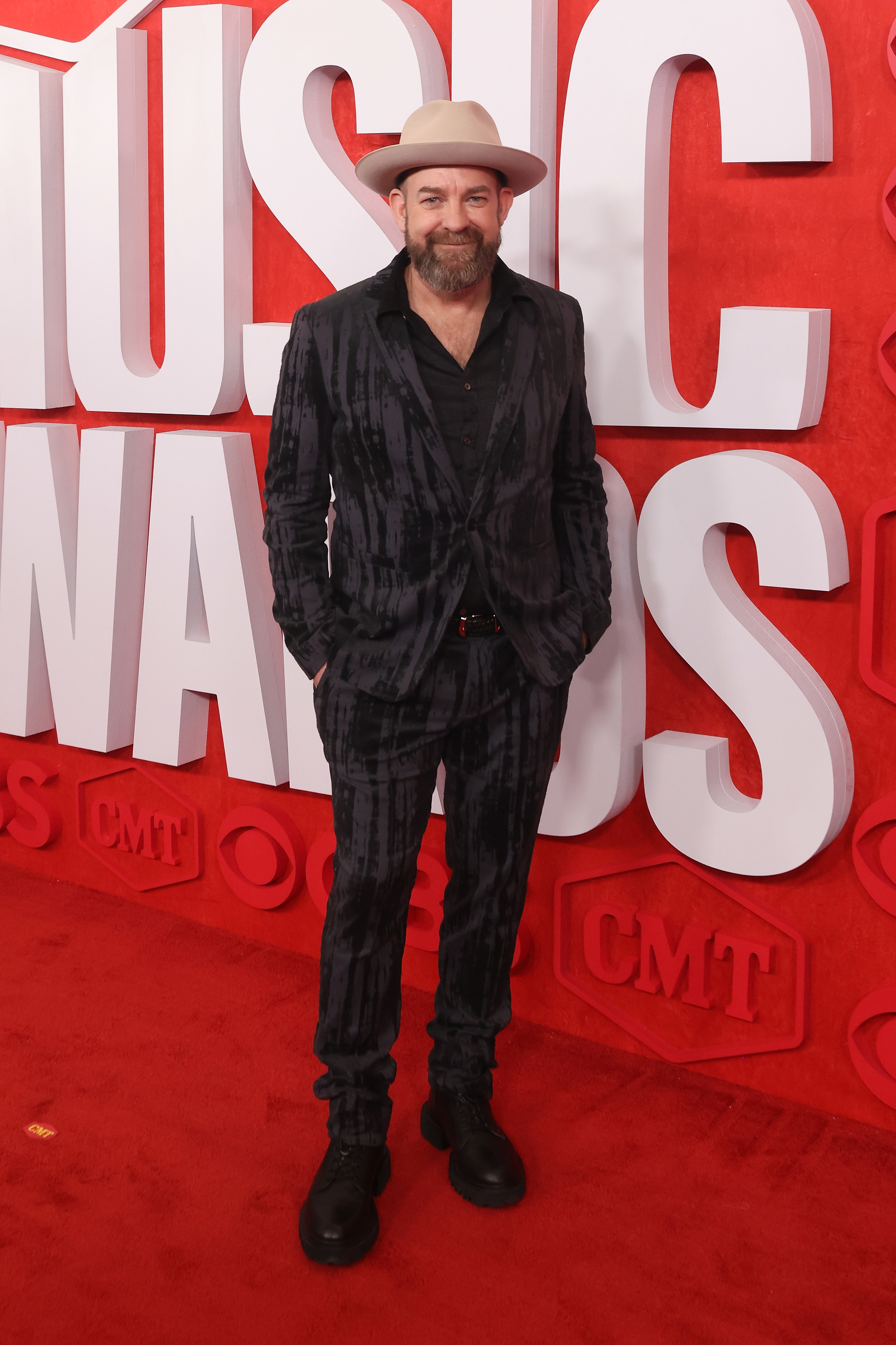 Man in pinstripe suit and hat posing at the CMT Music Awards