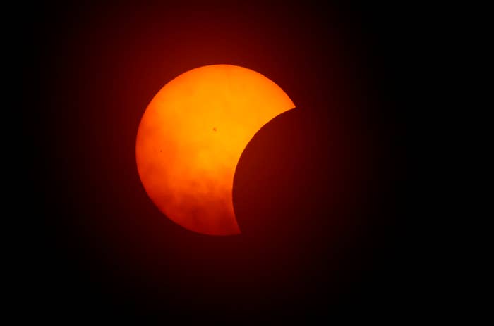 Partial solar eclipse with the moon covering a segment of the sun