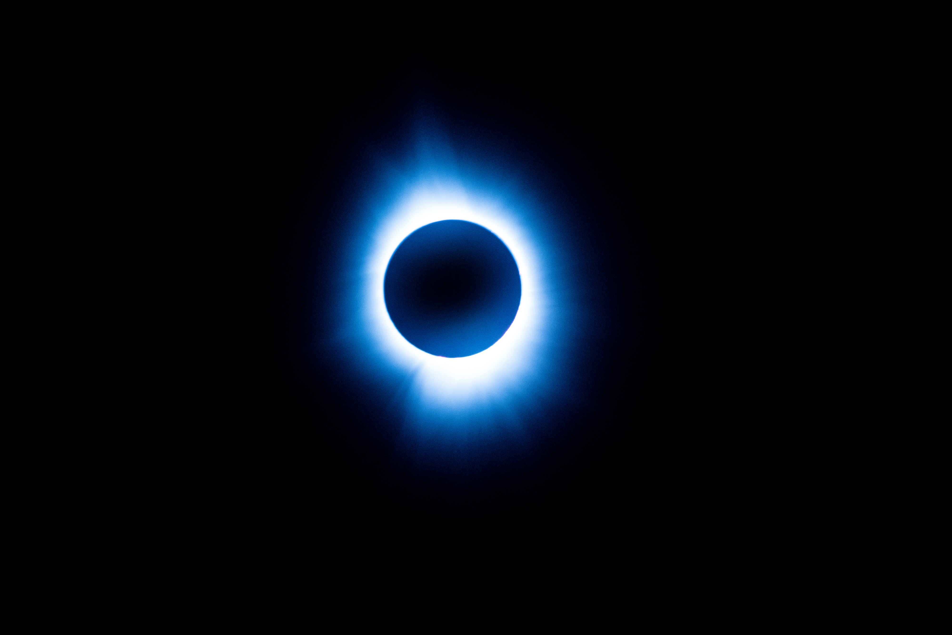 Total solar eclipse with a glowing corona visible around the obscured sun