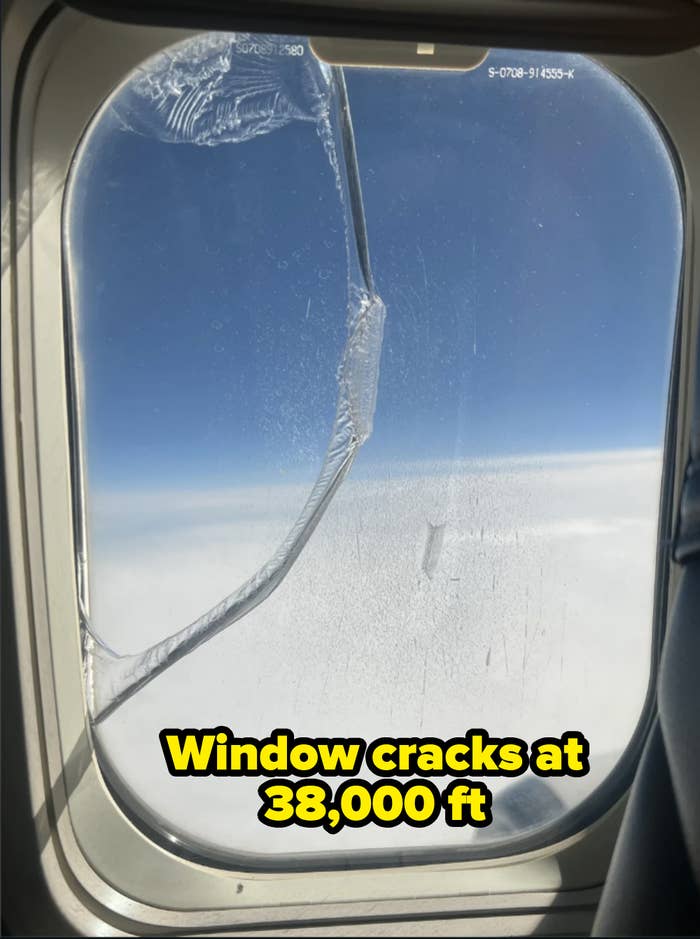 View from an airplane window with a crack in the ice on the glass