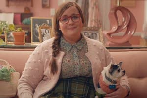 Aidy Bryant sitting on the couch next to a Chihuahua in an SNL sketch