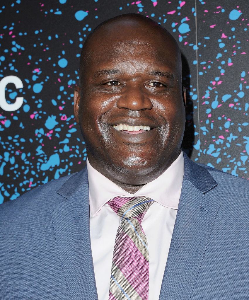 Shaquille O&#x27;Neal wearing a suit with a tie, smiling at an event
