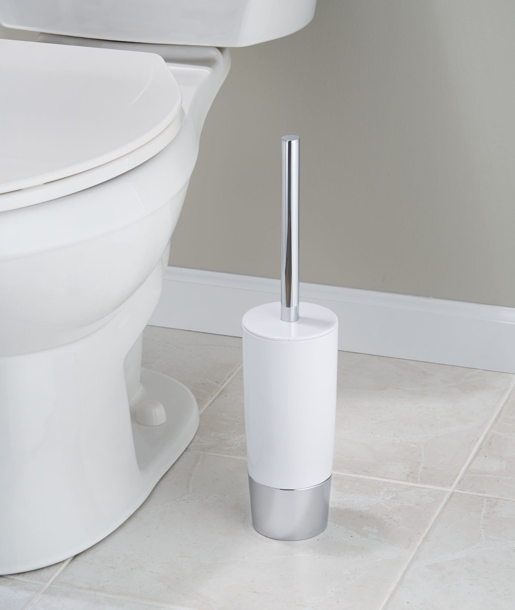 Modern minimalist toilet brush in a white holder next to a toilet
