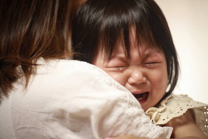 泣いている幼児を抱く女性が写っています。