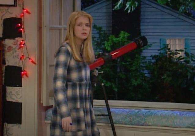 Character Clarissa from &quot;Clarissa Explains It All&quot; stands by a telescope, looking confused