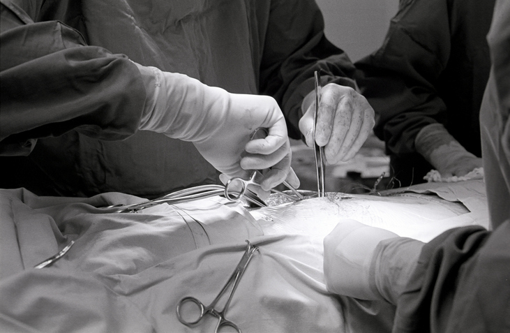 Surgeons performing an operation with various surgical instruments in use