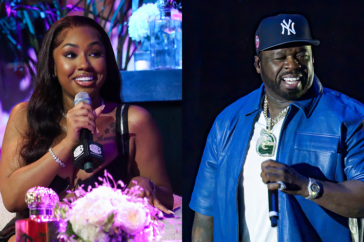 Megan Thee Stallion seated with microphone; 50 Cent standing in blue outfit, both smiling
