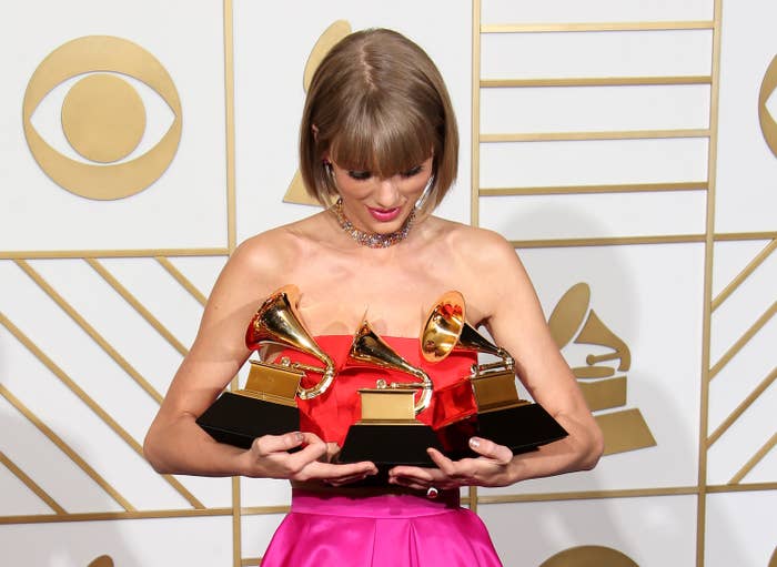 Taylor Swift holding three Grammys