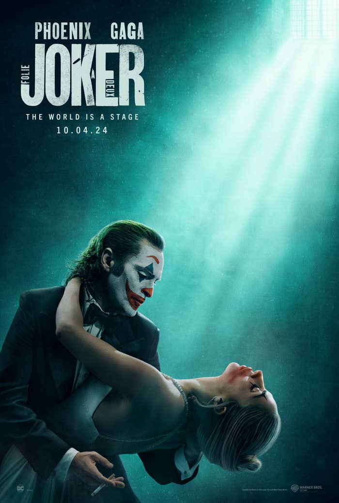 Promotional poster for &#x27;Joker&#x27; featuring Joaquin Phoenix in makeup, embracing Lady Gaga as Harley Quinn, with spotlight above