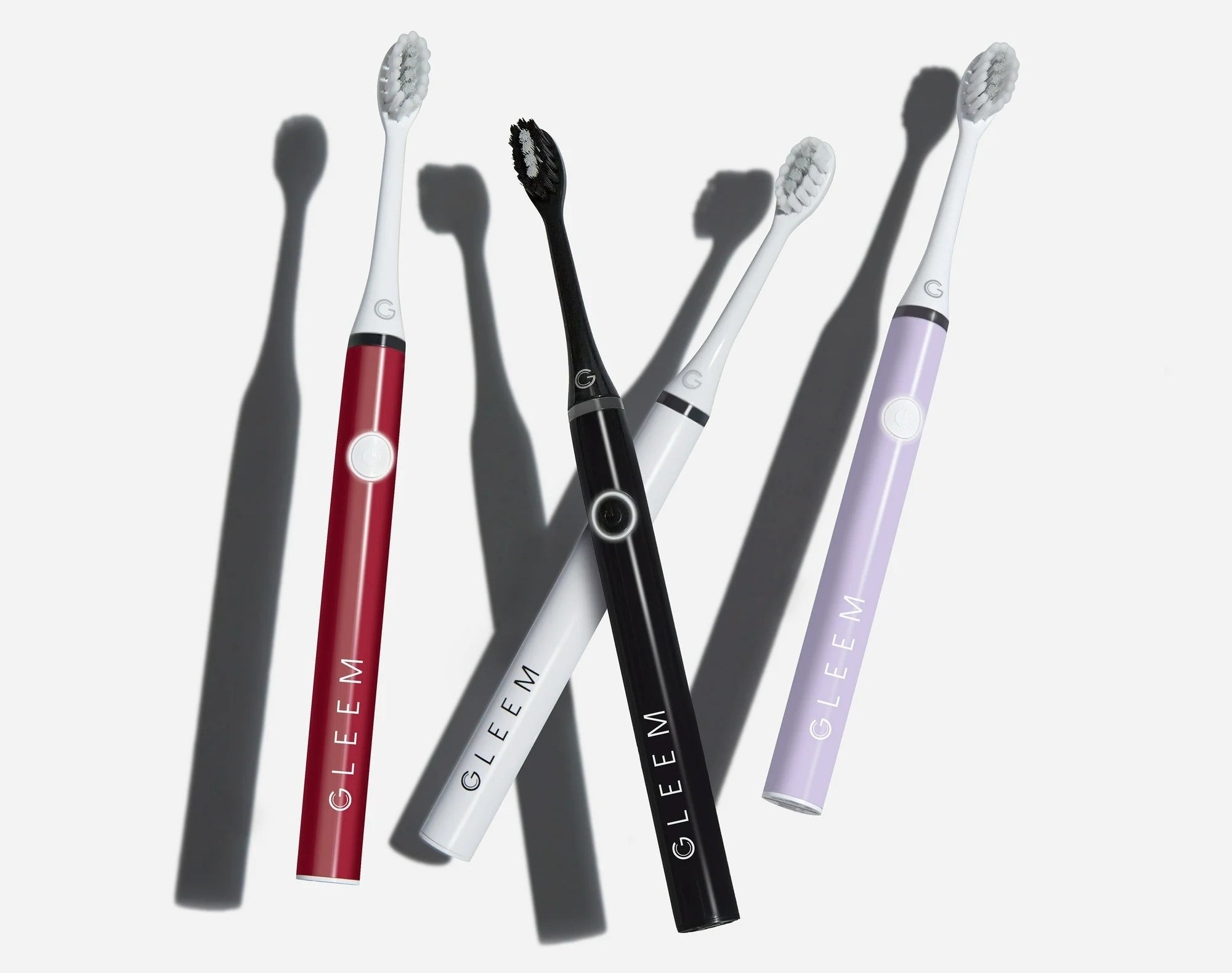 Four sleek electric toothbrushes in different colors