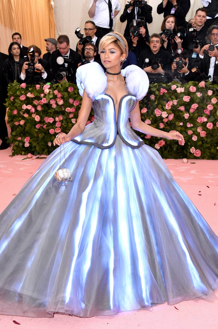 Zendaya wears a light-up Cinderella gown at a gala, with photographers in the background