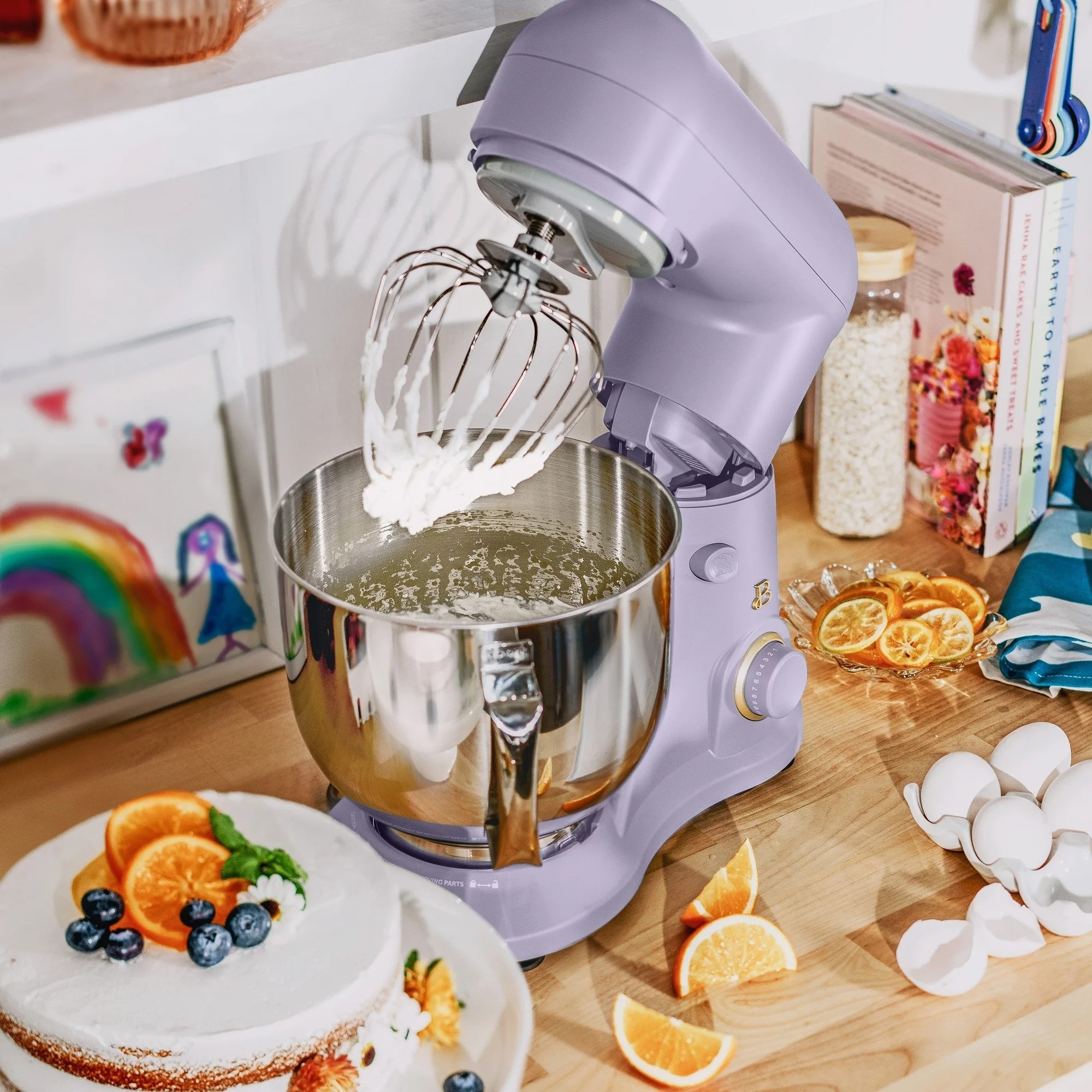 Stand mixer on a kitchen counter with ingredients around, mixing batter for baking